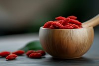 Dried goji berries in wooden bowl with spoon on kitchen counter. Superfood antioxidant snack for healthy eating and nutrition concepts.