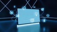 Futuristic laptop computer with glowing digital icons representing business technology, e-commerce, and connectivity on dark background.