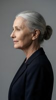 Professional senior woman with gray hair in profile view wearing dark business suit against neutral background for corporate and aging concepts.