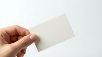 Hand holding blank white business card mockup on light background for branding and corporate identity design projects.