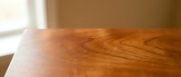 Close-up view of natural wood grain texture on polished wooden table surface with warm lighting creating elegant interior design element for home decor.