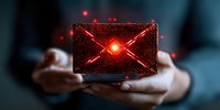 Glowing red envelope with X mark floating between hands against dark background, representing email security threat and spam warning concept.