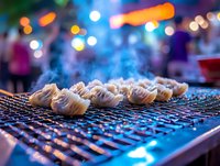 Steamed dumplings on grill with colorful bokeh lights in background, street food night market atmosphere creates vibrant dining scene.