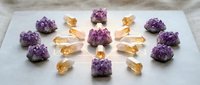 Purple amethyst and golden citrine crystal specimens arranged on white marble surface for healing meditation and spiritual energy practices.