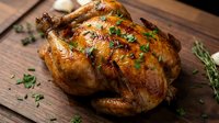 Golden roasted whole chicken with herbs on wooden cutting board, perfect for holiday meals, family dinners, and culinary presentations.