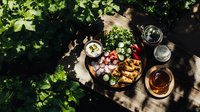 Fresh summer garden brunch with grilled vegetables, radishes, and dips served on rustic wooden board outdoors with dappled sunlight and green foliage.