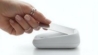 Woman's hand with manicured nails and silver rings holding white wireless computer mouse on isolated background for tech and office design use.
