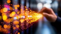 Professional businessman touching glowing digital particles with golden bokeh lights creating futuristic technology connection and data flow visualization.