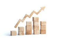 Wooden blocks arranged as ascending bar graph with upward trending arrow, representing business growth and success on white background.