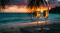 Two champagne glasses on tropical beach at sunset with palm fronds framing romantic ocean view for celebration and luxury vacation moments.