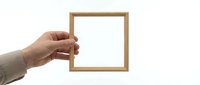 Hand holding empty wooden picture frame with white background, mockup template for artwork display, home decor and interior design projects.