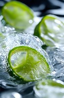 Fresh lime slices with melting ice cubes and water droplets on dark background, macro shot with selective focus for cocktail and beverage photography.