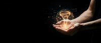 Hands holding glowing lightbulb with sparkling particles on dark background representing innovation, creativity, bright ideas and inspiration for business solutions.