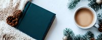 Cozy winter flat lay with teal book, coffee cup, pine branches and cone on white background. Seasonal reading and relaxation concept for holidays.
