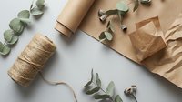 Eco-friendly gift wrapping supplies with kraft paper, natural twine and eucalyptus branches for sustainable packaging and zero waste lifestyle.