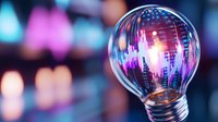 Glowing light bulb with financial chart reflection against blurred bokeh background showing market data and trading concept. Suitable for business innovation.