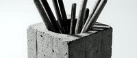 Black pencils and charcoal sticks arranged in a concrete holder, isolated on white background. Suitable for art supplies, design, education, and creative workspace concepts.