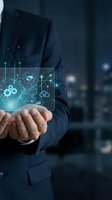 Businessman holding holographic digital interface with technology icons and data visualization in modern office environment for business innovation concepts.