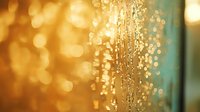 Glowing golden water drops on glass surface with bokeh effect in background creating magical atmosphere. Macro photography with soft focus and blur.