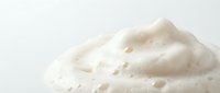 Creamy white whipped texture with smooth swirls and peaks on clean background for culinary and beauty applications.
