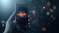 Smartphone displaying glowing heartbeat pulse line on dark screen with bokeh light effects and particles. Hand holding device in atmospheric lighting.