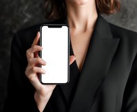 Professional businesswoman in black suit holding smartphone with blank white screen mockup for app presentation and digital marketing campaigns.