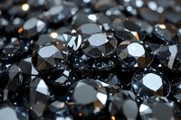 Black diamonds macro shot with selective focus showing brilliant cut facets and light reflections on dark luxury gemstones background for jewelry design.