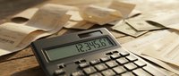 Calculator with financial documents and receipts on wooden desk for accounting, tax preparation, budgeting and business expense management tasks.