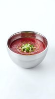 Vibrant beet soup served in white ceramic bowl, garnished with fresh diced cucumber and herbs, perfect for culinary and food styling projects.