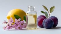Essential oil in glass bottle with fresh lemon, plums and pink flowers on light background, natural aromatherapy and organic skincare concept.