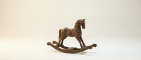 Vintage wooden rocking horse figurine on a light background, a classic decorative toy with intricate carved details and warm brown tones.