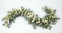 Elegant eucalyptus garland with white flowers and berries on white background, isolated floral decoration for weddings, events and home decor projects.