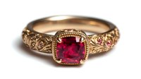 Vintage gold engagement ring with square-cut ruby gemstone centerpiece and intricate filigree band design, set against white background.