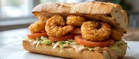 Crispy golden fried shrimp sandwich with fresh lettuce and tomato on artisan bread, gourmet seafood meal ready for restaurant menu or food blog content.