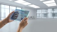 Hands holding transparent tablet displaying financial data charts and graphs in modern office space for business analytics and digital technology applications.