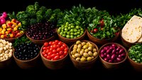 Colorful variety of fresh olives, tomatoes and vegetables in wooden bowls arranged in row on dark background. Mediterranean appetizers and ingredients.