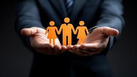 Male hands in business suit holding glowing orange figures representing family or team unity against dark background, symbolizing care, protection and support.