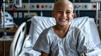 Young patient in hospital gown smiling brightly while sitting in hospital bed, medical equipment visible in background, showing hope and resilience during treatment.
