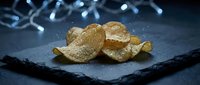 Gourmet truffle slices arranged on dark slate plate with elegant bokeh lighting background for luxury culinary presentation and fine dining concepts.