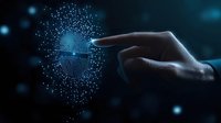 Finger touching digital biometric scan with glowing particles forming circular pattern on dark background. Futuristic security technology concept.