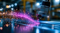 Vibrant pink and orange sparks fly from industrial laser cutting machine in manufacturing facility with dramatic lighting and bokeh reflections on metallic surface.