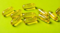 Golden yellow vitamin capsules scattered on bright lime green background for health and wellness supplement marketing materials.
