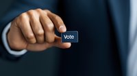 Close-up of business person's hand pressing virtual vote button against dark background, representing digital democracy and electronic voting concept.