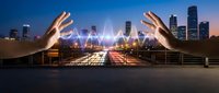 Hands reaching toward glowing network connections over city skyline at dusk, representing digital transformation and smart city technology concepts.