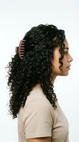Woman with long curly black hair wearing wooden hair comb, side profile portrait against white background for hair care and beauty product marketing.