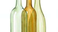 Empty glass bottles in green and amber colors isolated on white background for recycling and eco-friendly packaging design projects.