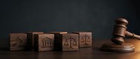 Wooden gavel and legal symbol blocks on dark background representing justice, law, court proceedings and legal services for attorneys and law firms.