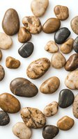 Collection of smooth river rocks and pebbles in natural earth tones scattered on white background, isolated for design projects and decorative elements.
