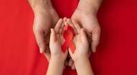 Hands protecting red ribbon symbol for HIV AIDS awareness and support on vibrant red background representing healthcare advocacy and solidarity.