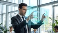 Businessman in dark suit and tie interacting with holographic data visualization displaying charts and spiral graphics in modern office with glass walls and plants.